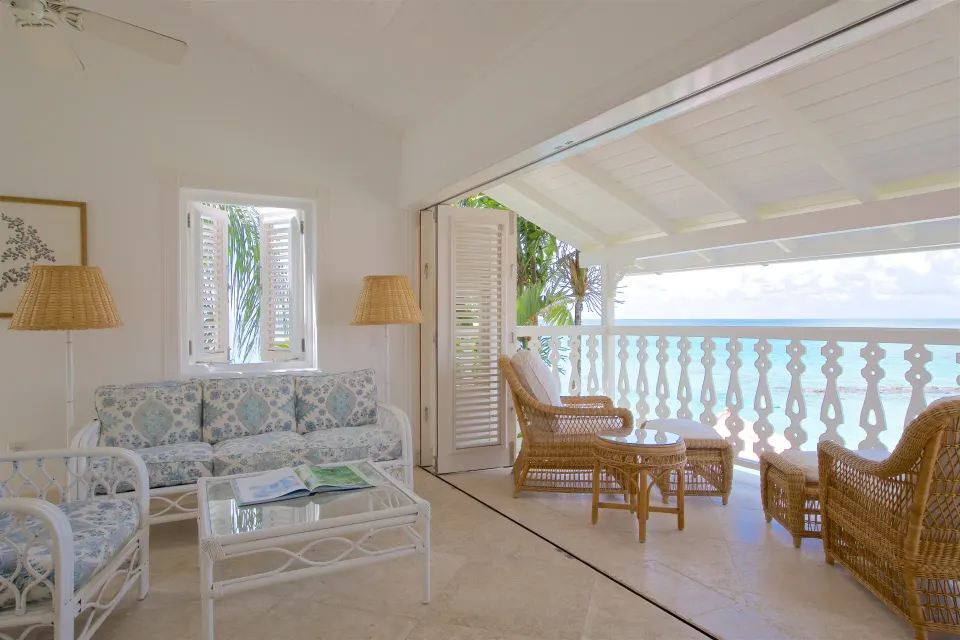 Ocean Front Suite lounge opening to a furnished ocean-view balcony at Cobblers Cove.