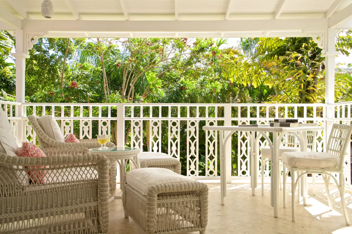 Royal Circle Suite veranda with wicker lounge seating and garden view at Cobblers Cove.