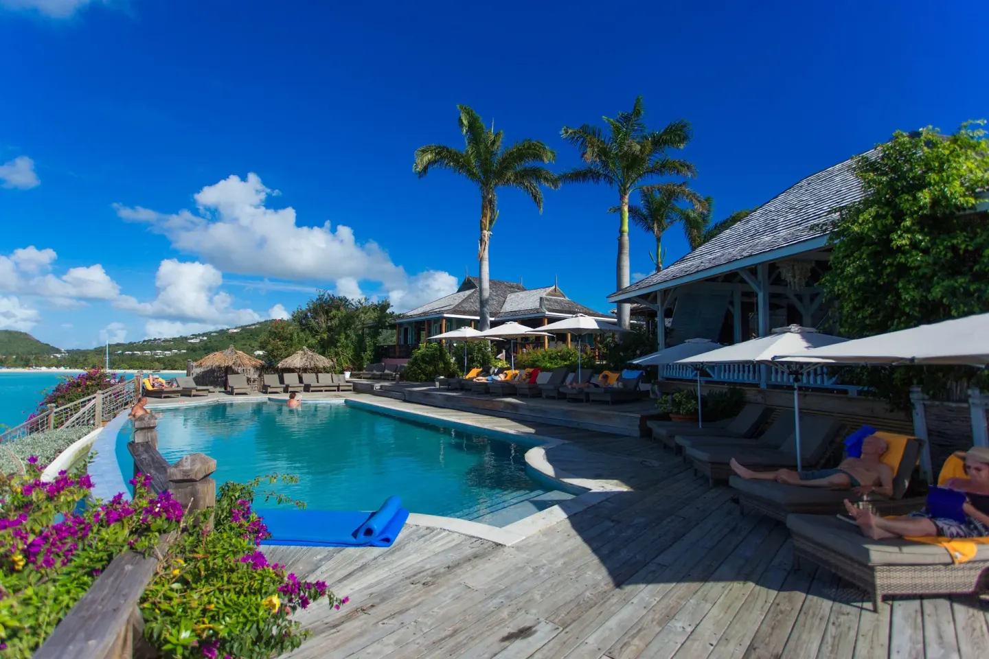 Guests relax beside the oceanfront pool and deck at Cocobay Resort.