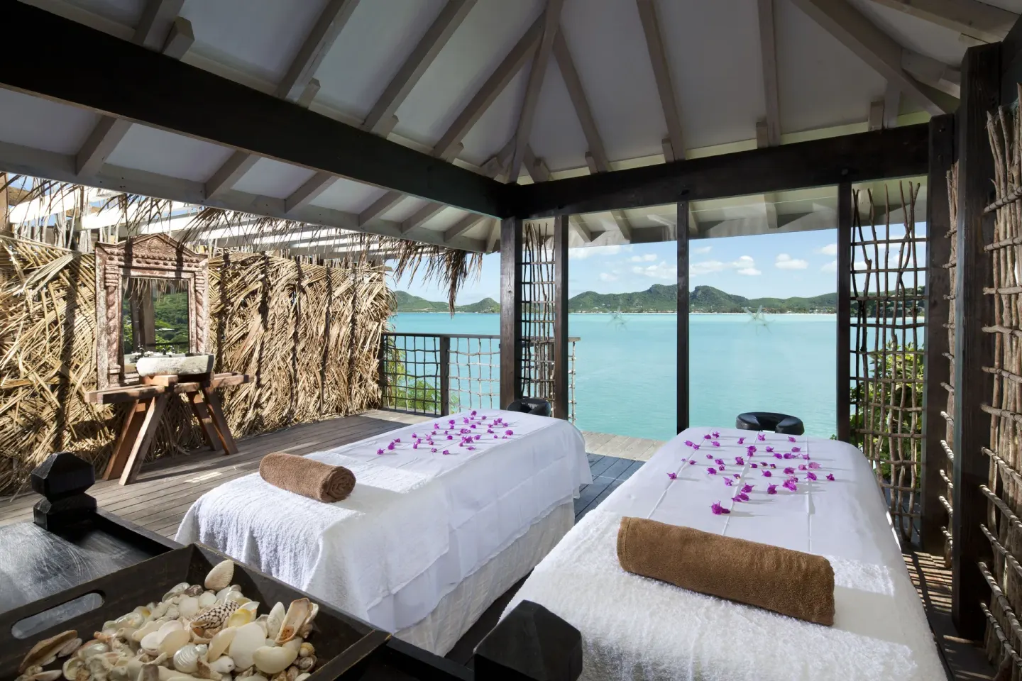 Open-air spa treatment beds overlooking the bay at Cocobay Resort.