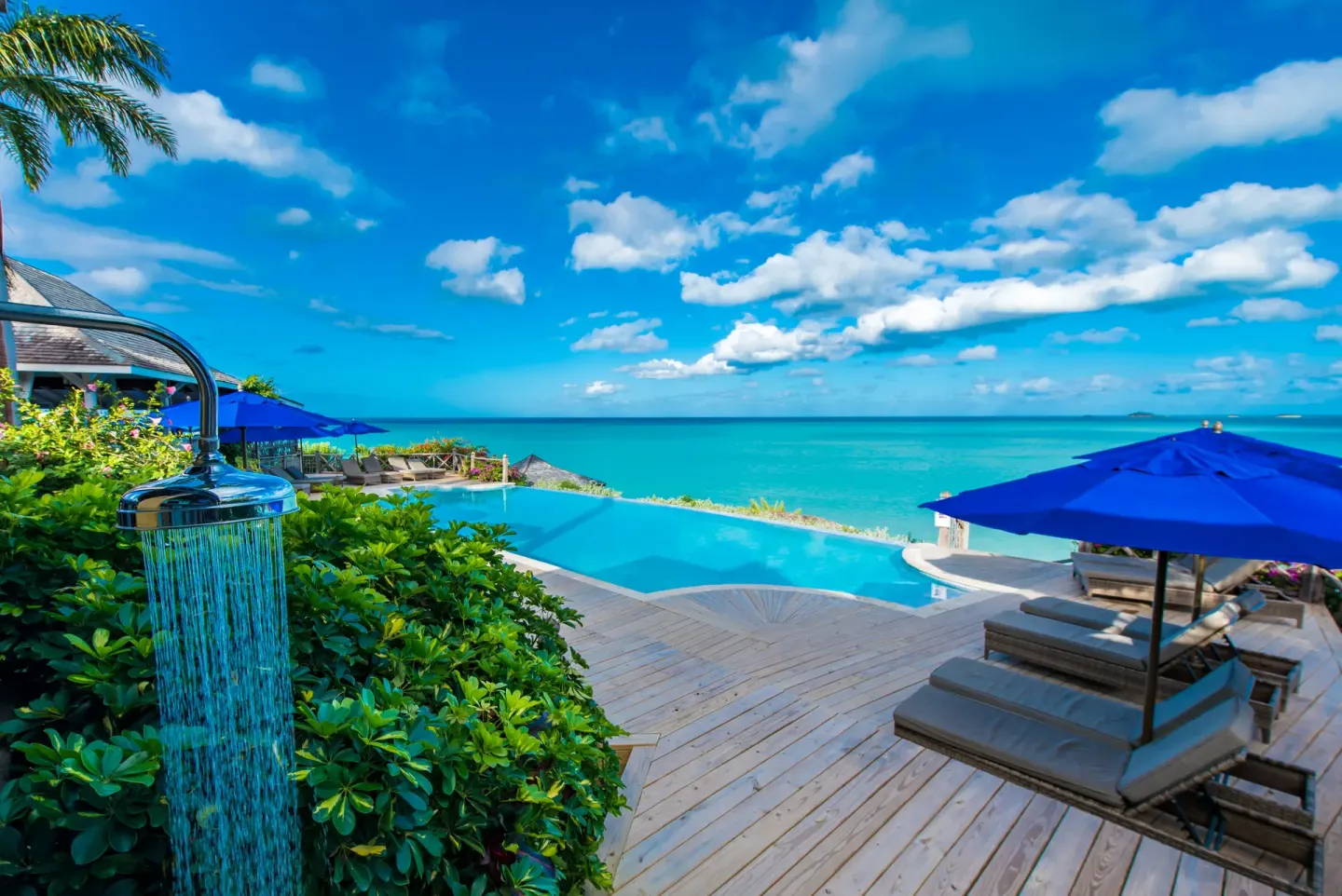 Outdoor shower, infinity pool, loungers, and ocean view at Cocobay Resort.