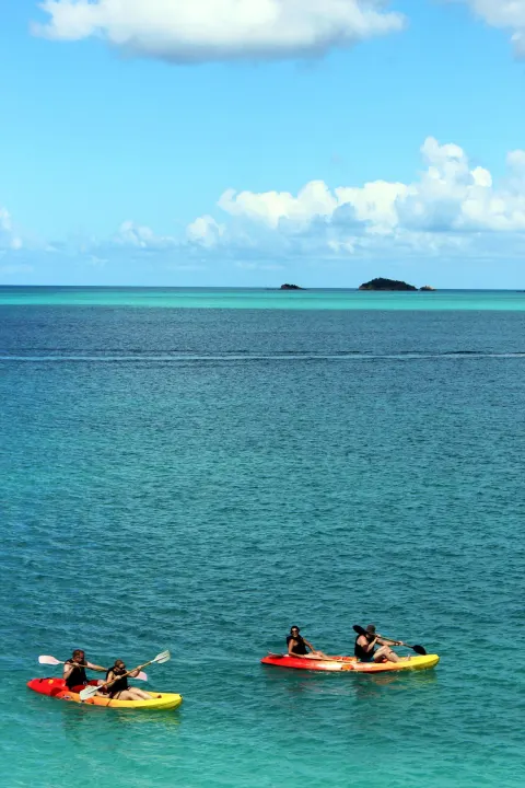 Kayakers paddle over clear blue water near Cocobay Resort.