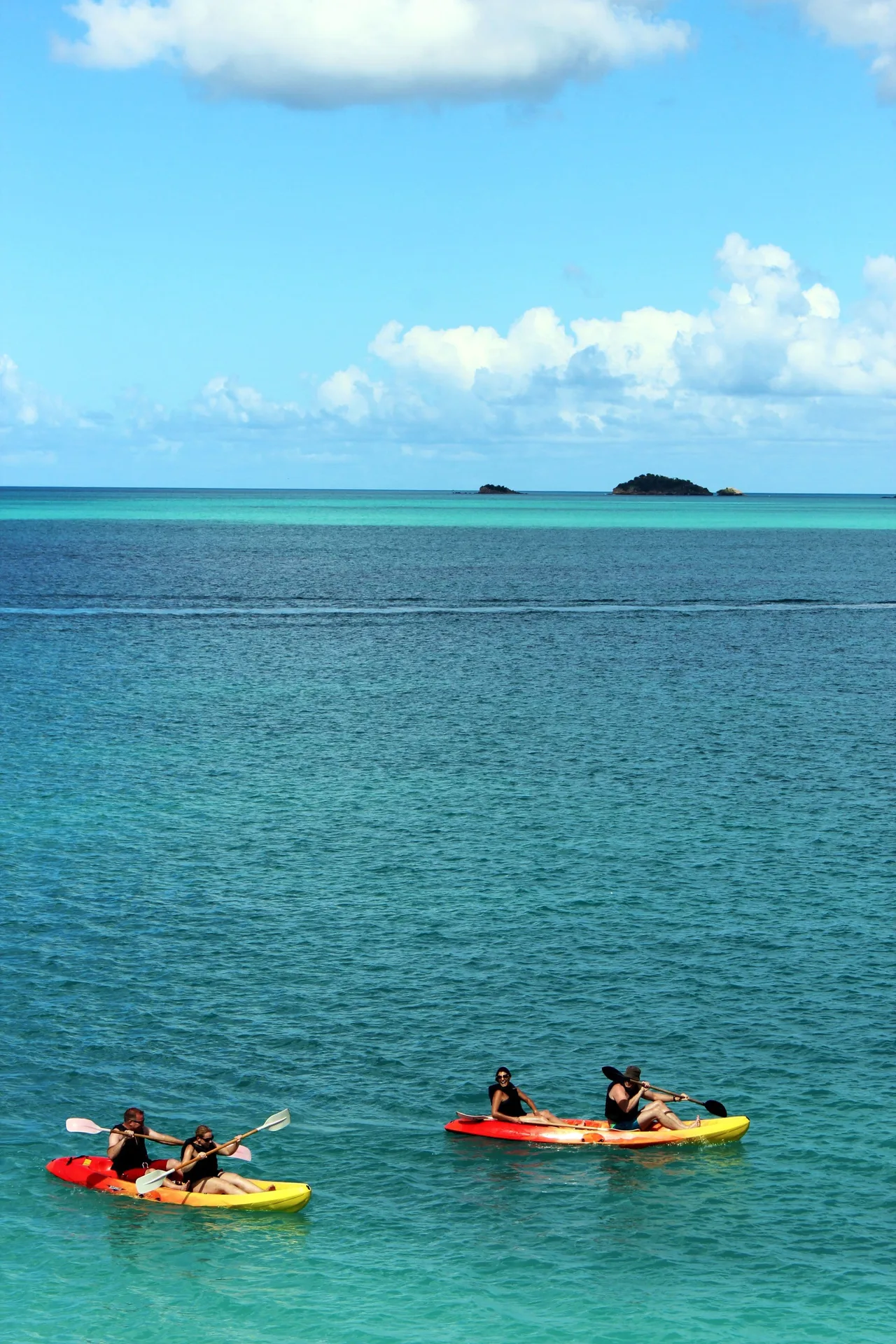 Kayakers paddle over clear blue water near Cocobay Resort.
