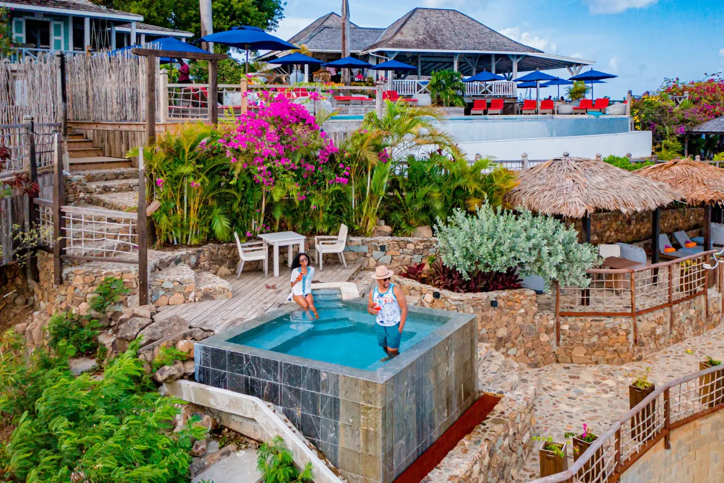 Terraced pools, thatched cabanas, and colorful flowers are shown at Cocobay Resort.