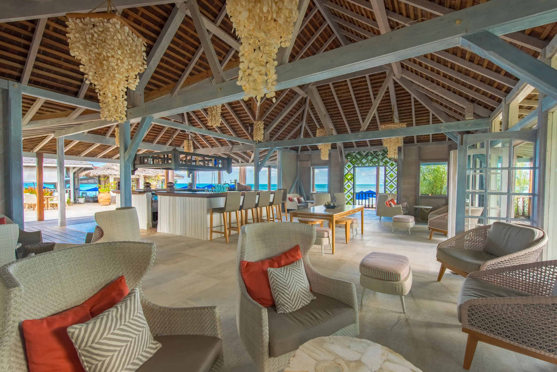 Open lounge with bar seating and ocean glimpses at Cocobay Resort.