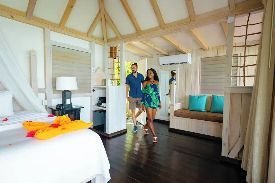 Panoramic Suite bedroom with canopy bed and sitting nook at Cocobay Resort.