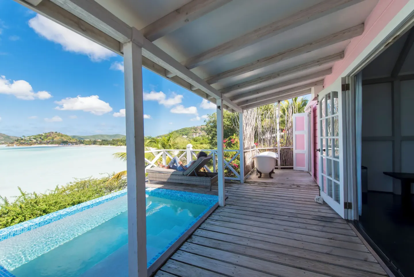 Sea-facing deck at Cocobay Resort with a private pool, loungers, and outdoor tub.