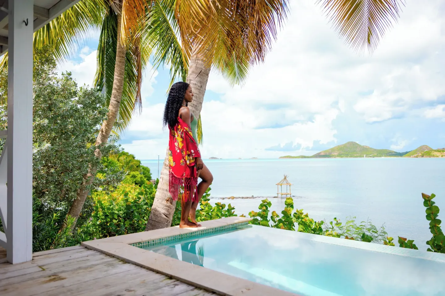 Private pool terrace at Cocobay Resort overlooking calm blue water beneath palm trees.