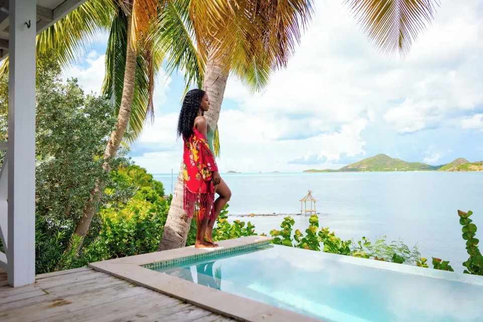 Private pool terrace at Cocobay Resort overlooking calm blue water beneath palm trees.