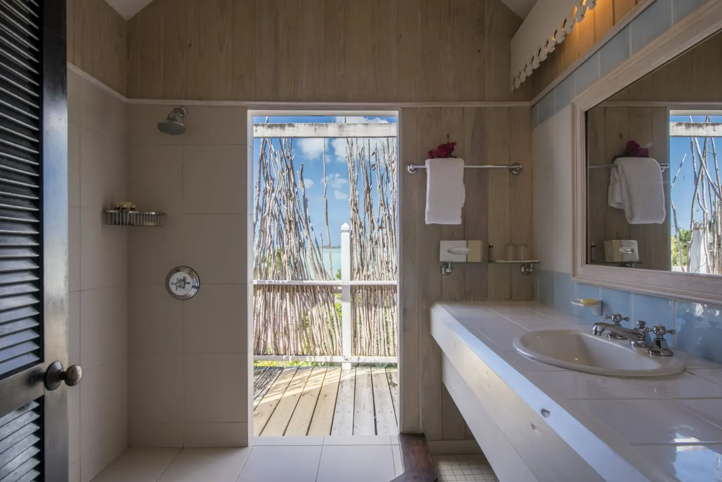 Standard Cottage Garden View bathroom with shower and vanity at Cocobay Resort.