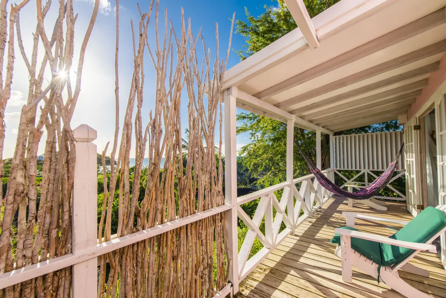 Standard Cottage Garden View veranda with hammock and lounge chair at Cocobay Resort.