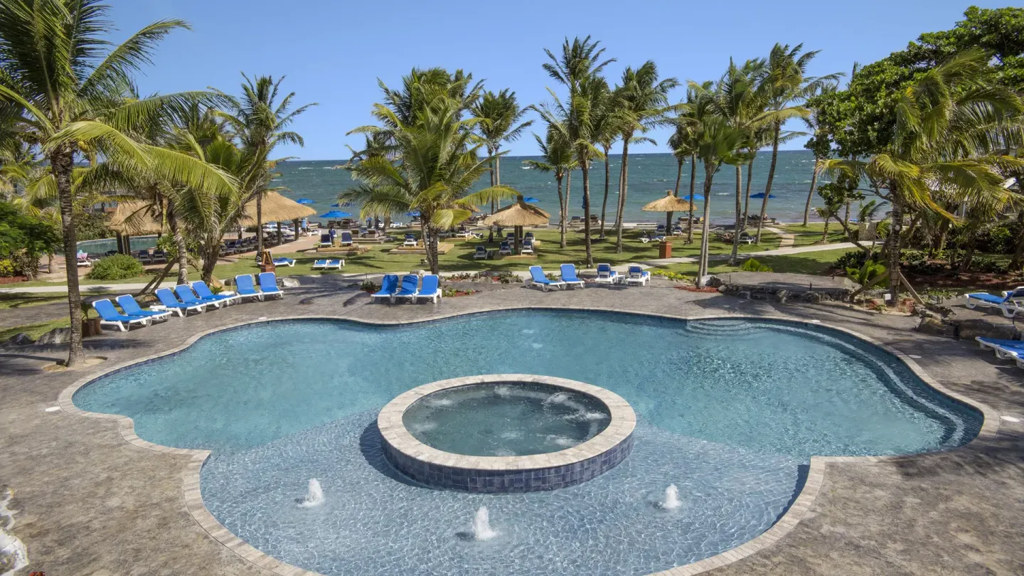 Beachfront pool with circular spa and palms at Coconut Bay Beach Resort & Spa.