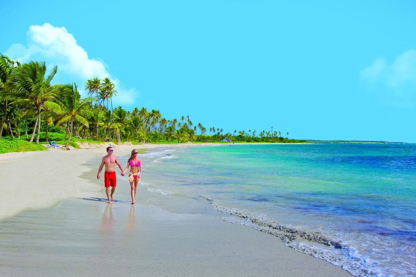 Couple walking along the beach at Coconut Bay Beach Resort & Spa.