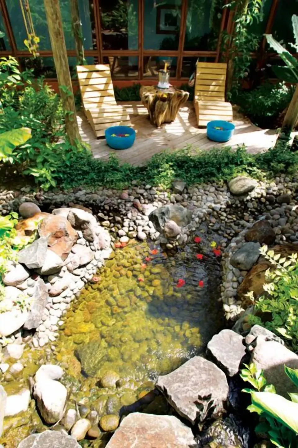 Garden water feature beside wooden loungers at Coconut Bay Beach Resort & Spa.