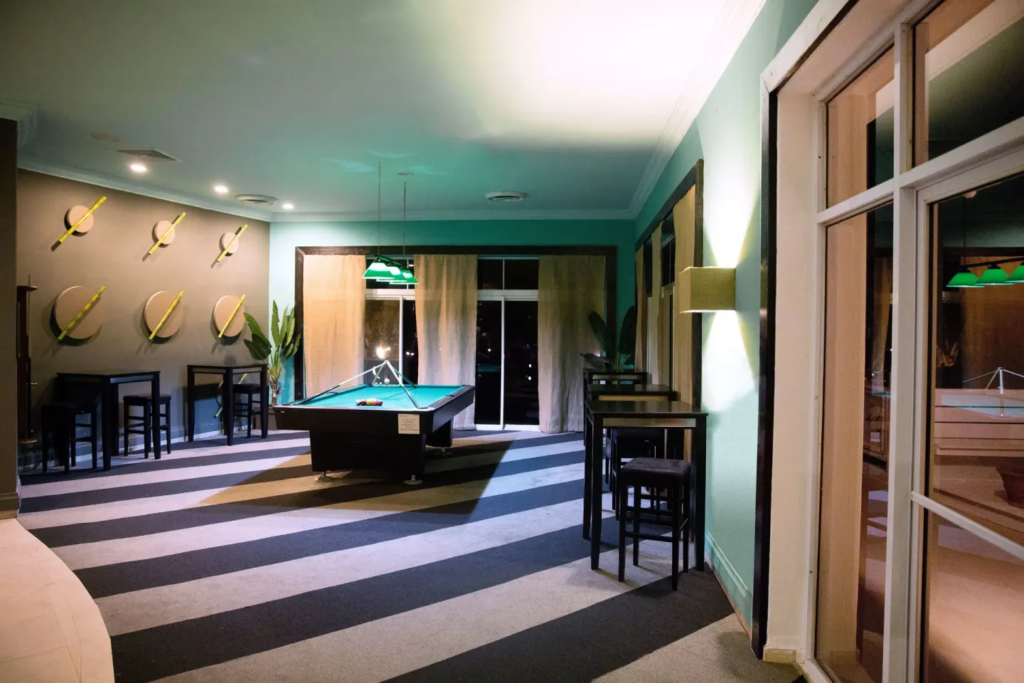 Indoor game room with pool table and high-top seating at Coconut Bay Beach Resort & Spa.