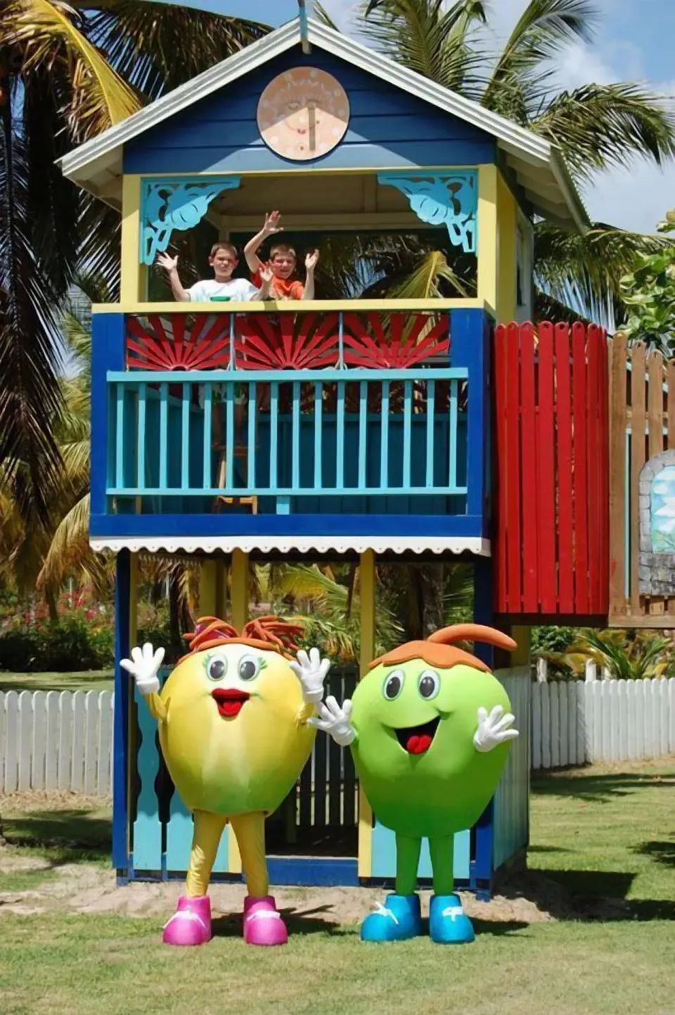 Colorful kids' clubhouse with waving children and mascots at Coconut Bay Beach Resort & Spa.