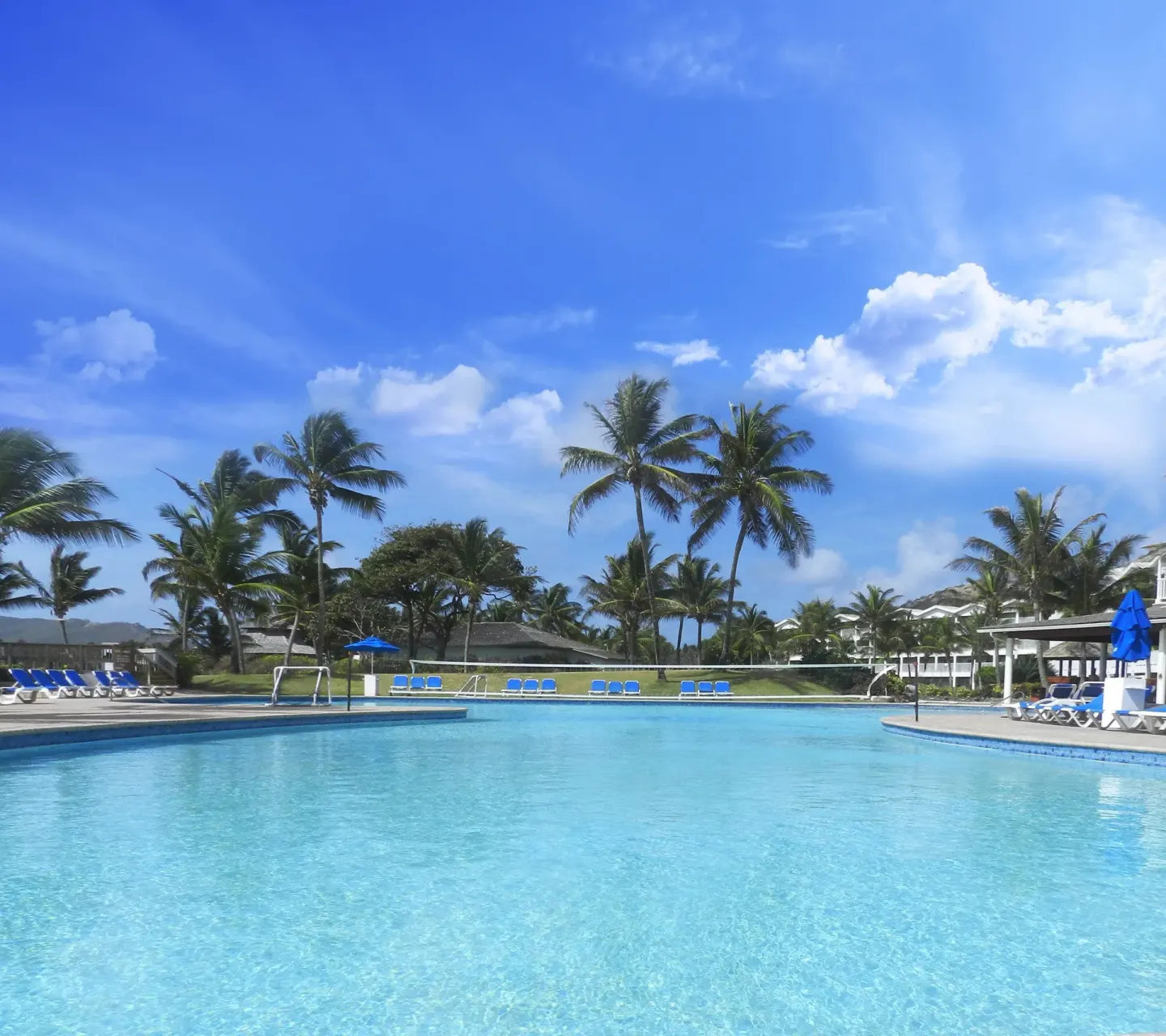 Large resort pool under palms and blue sky at Coconut Bay Beach Resort & Spa.