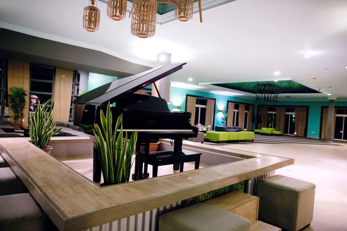 Lobby lounge with a black grand piano and seating at Coconut Bay Beach Resort & Spa.