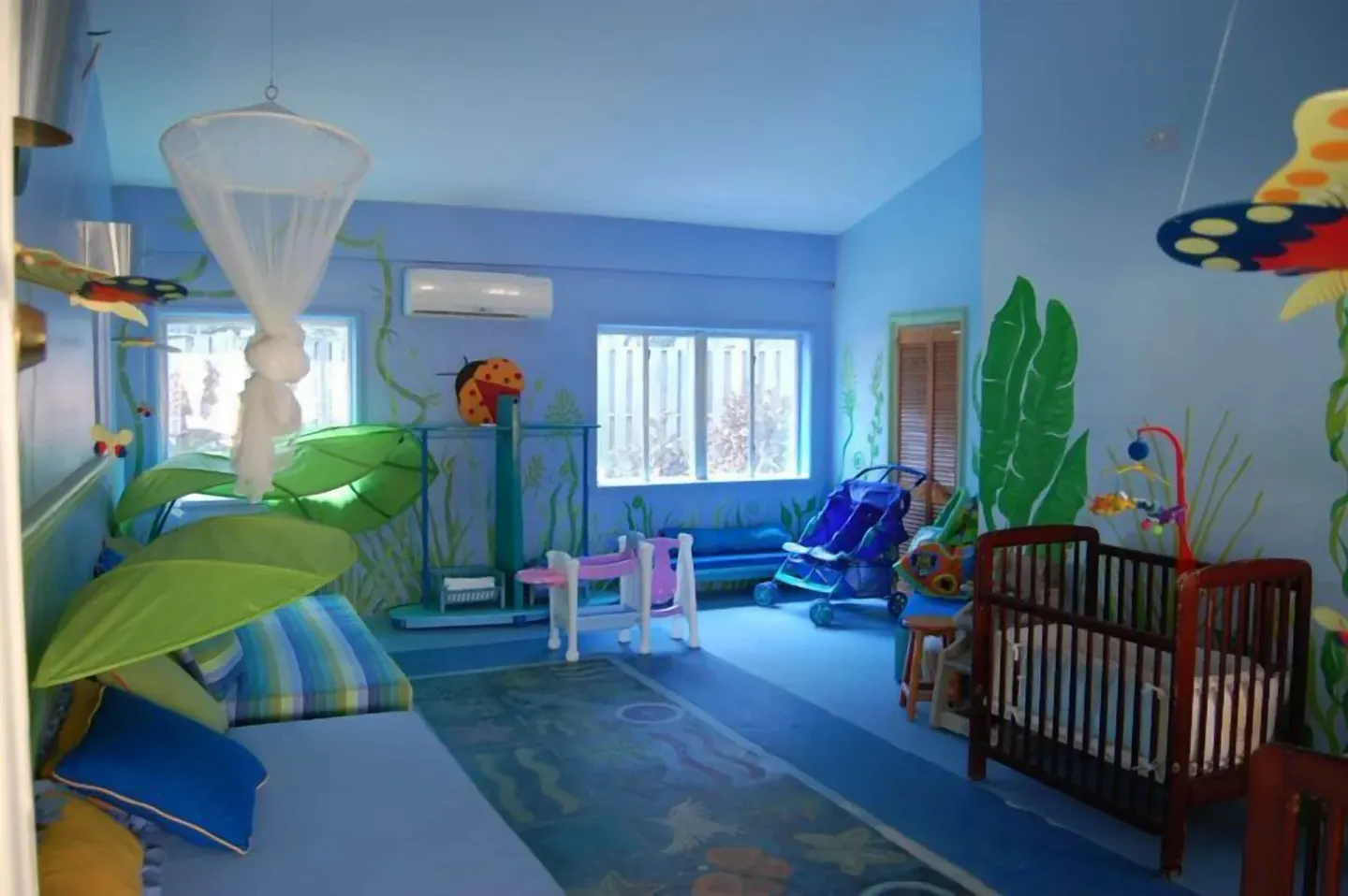Blue nursery room with crib and play equipment at Coconut Bay Beach Resort & Spa.