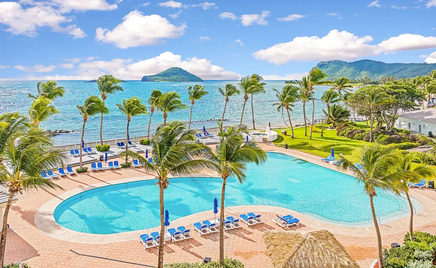 Oceanfront pool with palms and mountain views at Coconut Bay Beach Resort & Spa.