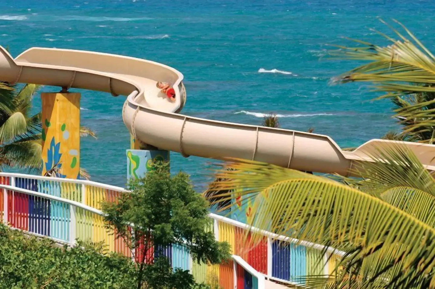 Waterslide curving above the ocean at Coconut Bay Beach Resort & Spa.