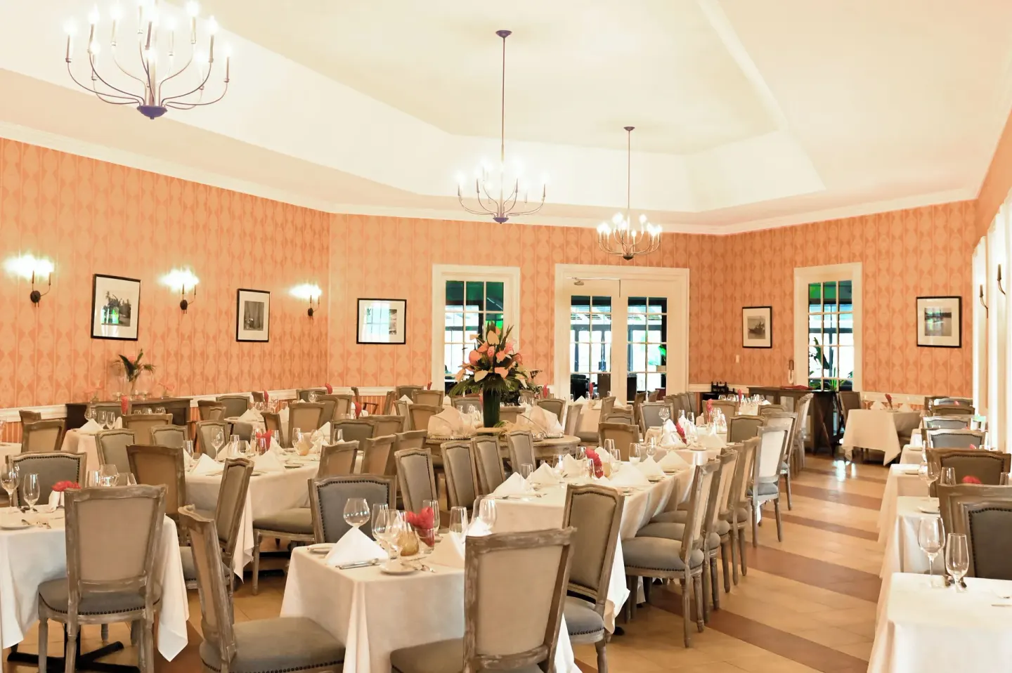 Elegant peach dining room with chandeliers at Coconut Bay Beach Resort & Spa.