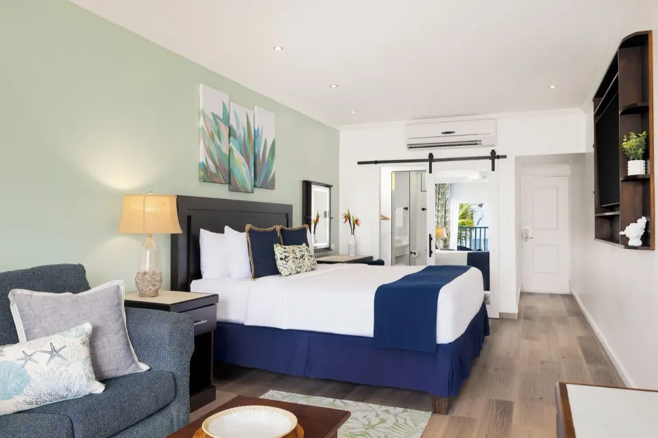 King bed, sofa, and sliding bath door in a Harmony JR Suite at Coconut Bay Beach Resort & Spa.
