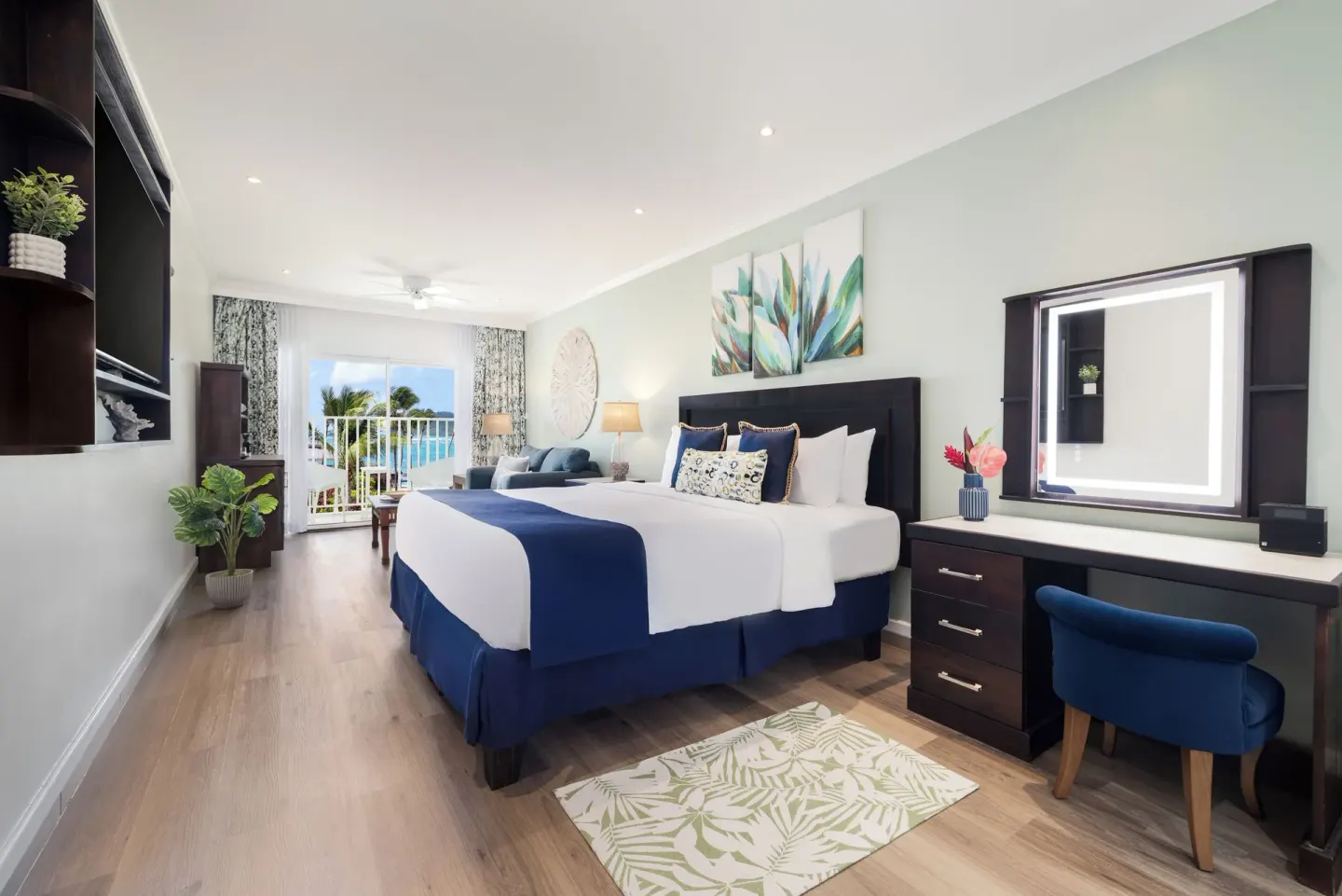King bed and vanity in a Harmony JR Suite Ocean View at Coconut Bay Beach Resort & Spa.