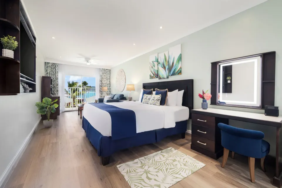 King bed and vanity in a Harmony JR Suite Ocean View at Coconut Bay Beach Resort & Spa.