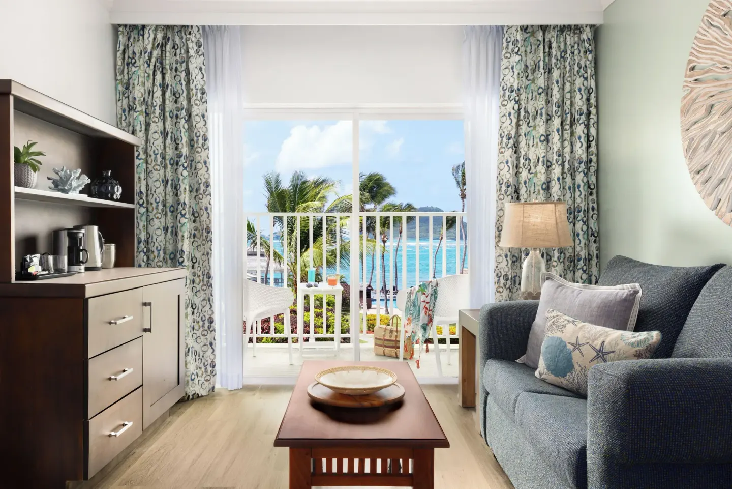 Sitting area and balcony ocean view in a Harmony JR Suite at Coconut Bay Beach Resort & Spa.
