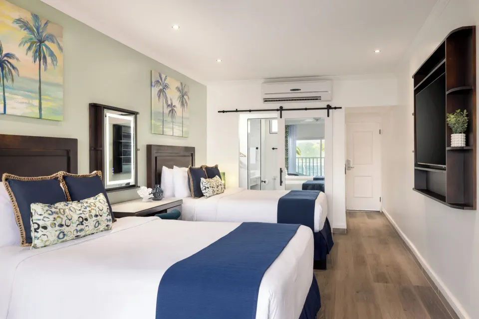 Two queen beds and entry area in a Harmony JR Suite at Coconut Bay Beach Resort & Spa.