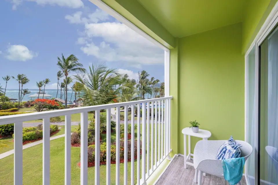 Harmony JR Suite Partial Ocean View balcony at Coconut Bay Beach Resort & Spa with chairs and ocean beyond.