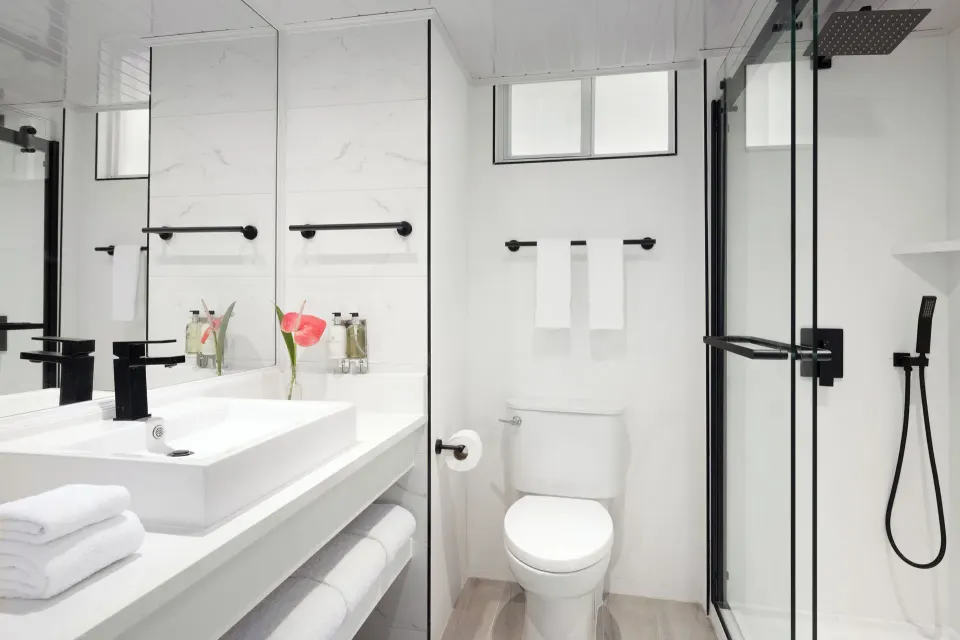 Harmony JR Suite bathroom with vanity and glass shower at Coconut Bay Beach Resort & Spa.