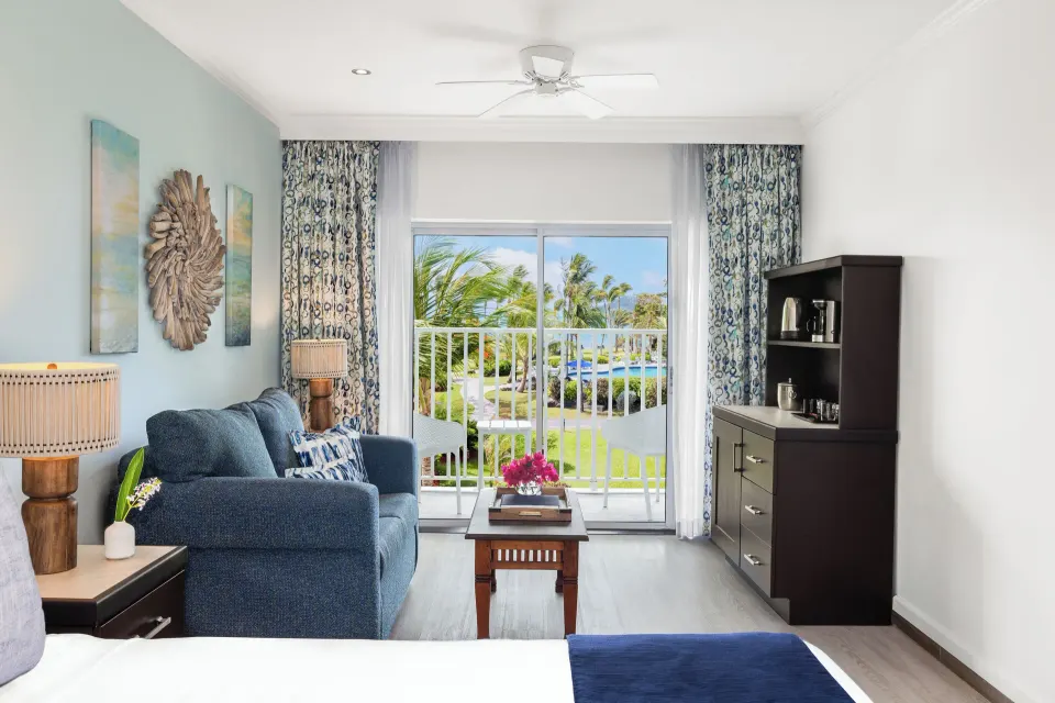 Harmony JR Suite Partial Ocean View lounge area at Coconut Bay Beach Resort & Spa beside the balcony doors.