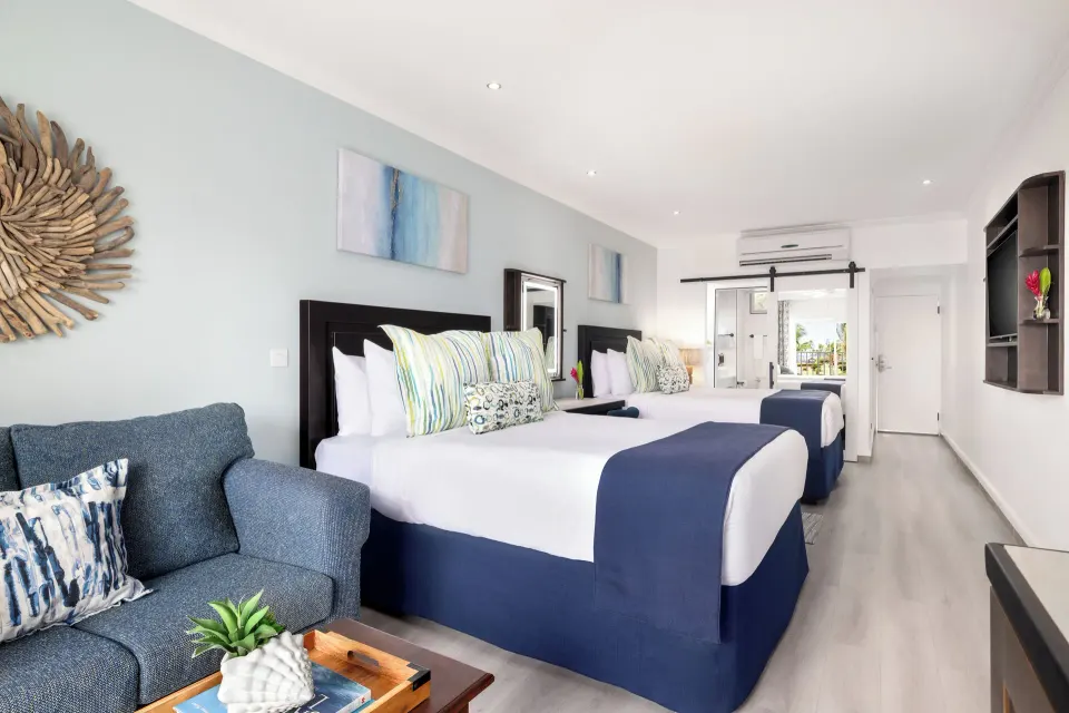 Harmony JR Suite Partial Ocean View guest room at Coconut Bay Beach Resort & Spa with sofa and two beds.