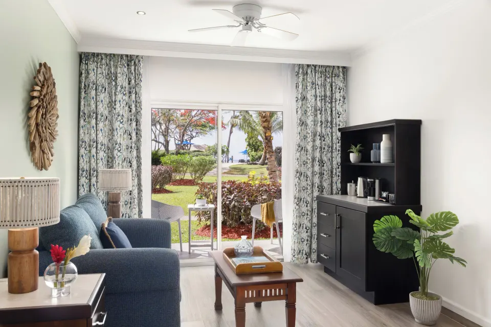 Sitting area and garden-facing patio in a Harmony JR Suite at Coconut Bay Beach Resort & Spa.