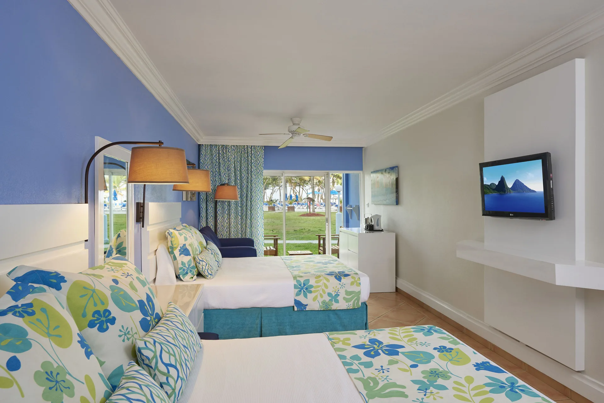Two double beds in a Splash Deluxe Garden View room at Coconut Bay Beach Resort & Spa.