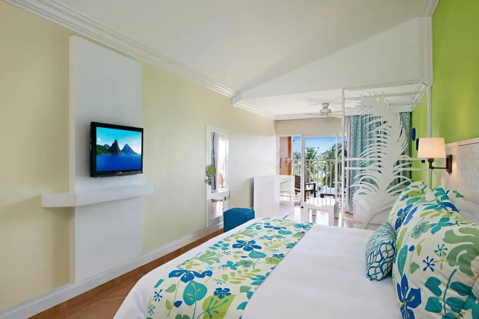 King bed in a Splash Premium Oceanview room at Coconut Bay Beach Resort & Spa with balcony doors beyond.
