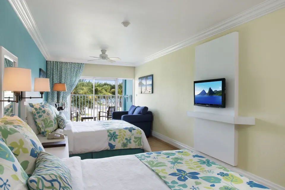 Two double beds in a Splash Premium Oceanview room at Coconut Bay Beach Resort & Spa with balcony seating.