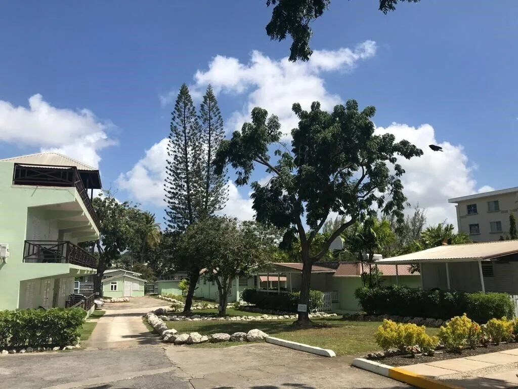 Landscaped driveway and guest buildings on the grounds of Coconut Court Beach Hotel.