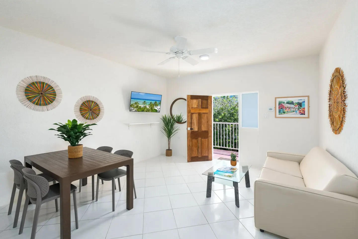 Bright living and dining area with sofa and balcony door at Coconut Court Beach Hotel.