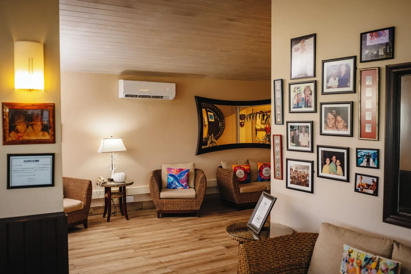 Lobby lounge with wicker chairs, photo wall, and wall mirror at Coconut Court Beach Hotel.