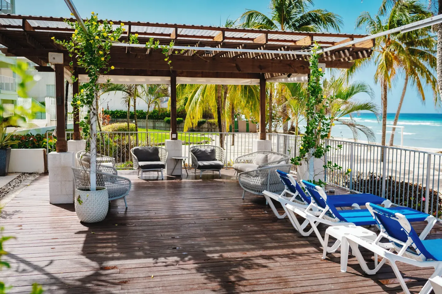Oceanfront deck with lounge chairs and seating at Coconut Court Beach Hotel.