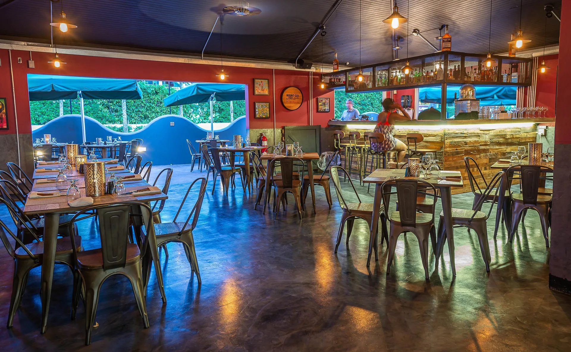 Indoor restaurant and bar with set tables and a glowing counter at Coconut Court Beach Hotel.