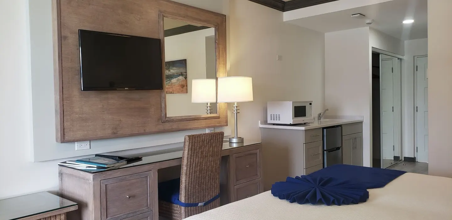 Partial Ocean View room desk, TV and kitchenette at Coconut Court Beach Hotel.
