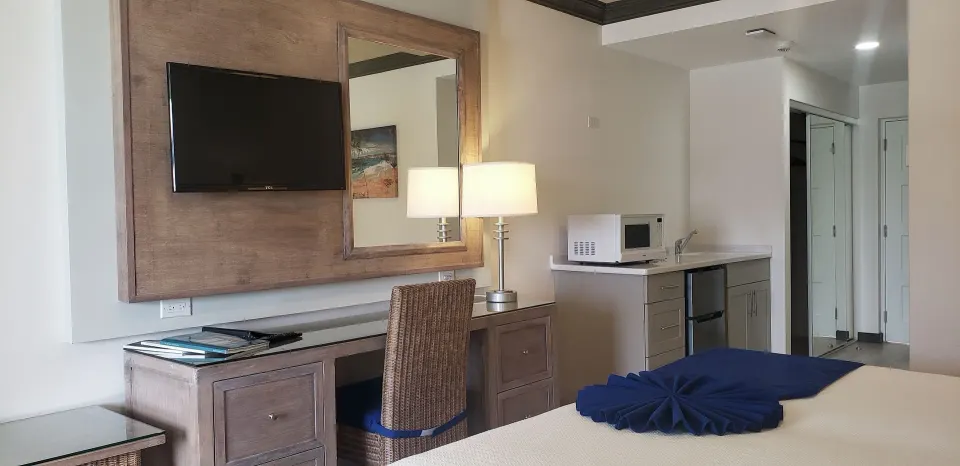 Partial Ocean View room desk, TV and kitchenette at Coconut Court Beach Hotel.