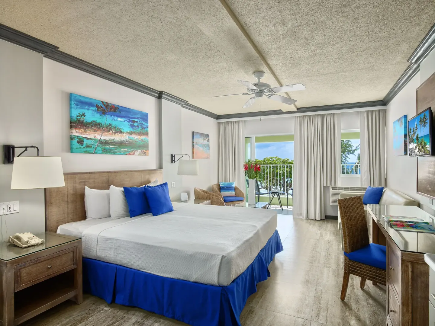 Partial Ocean View room with king bed and balcony at Coconut Court Beach Hotel.