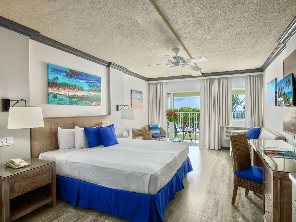 Partial Ocean View room with king bed and balcony at Coconut Court Beach Hotel.