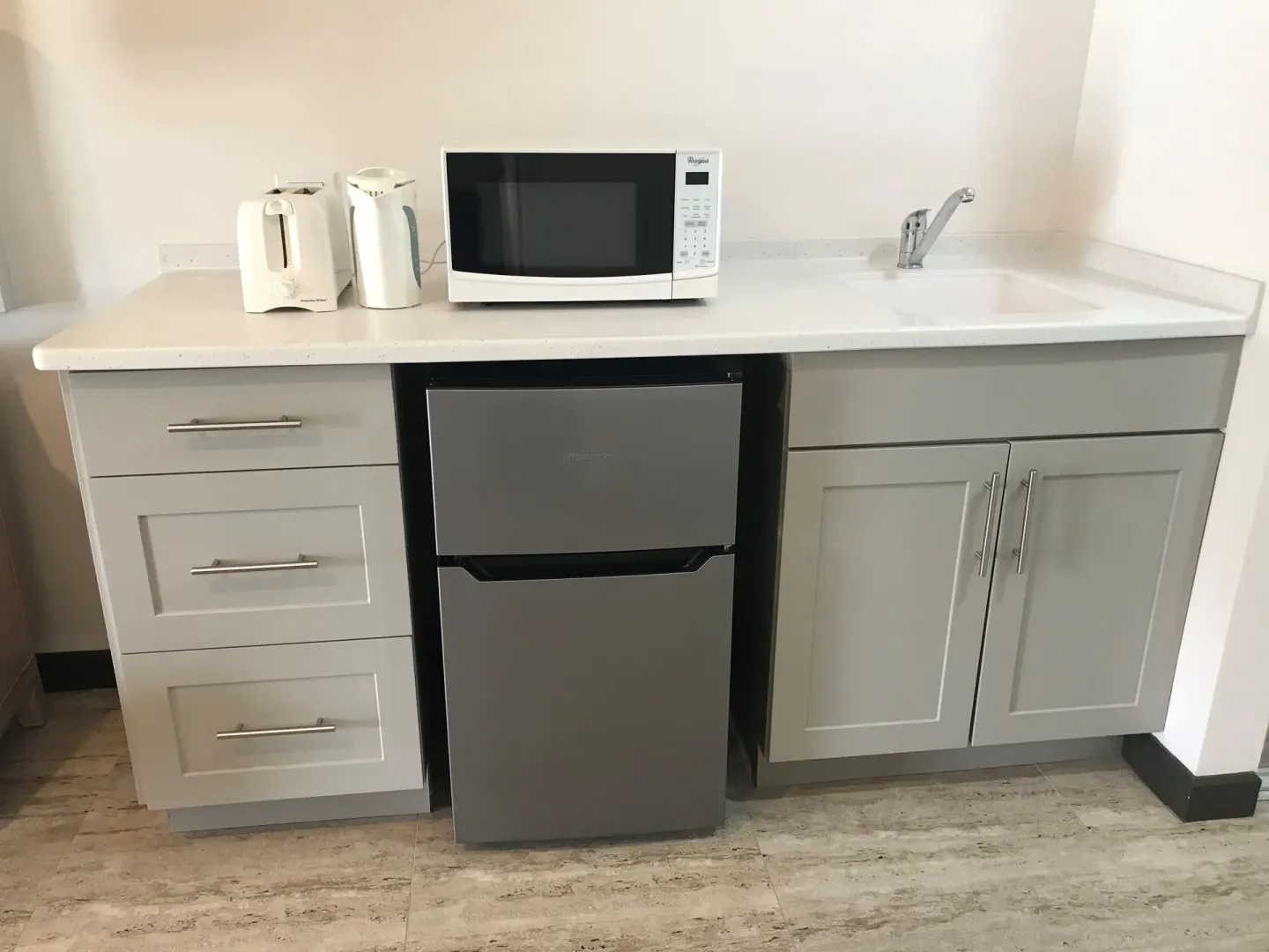 Partial Ocean View room kitchenette with microwave and mini fridge at Coconut Court Beach Hotel.