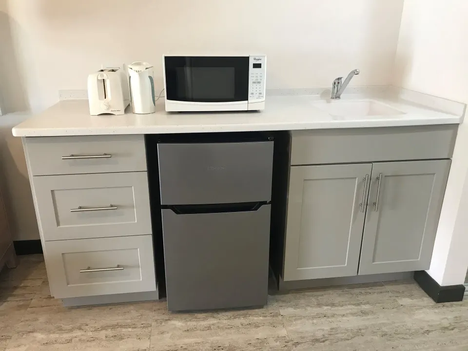 Partial Ocean View room kitchenette with microwave and mini fridge at Coconut Court Beach Hotel.